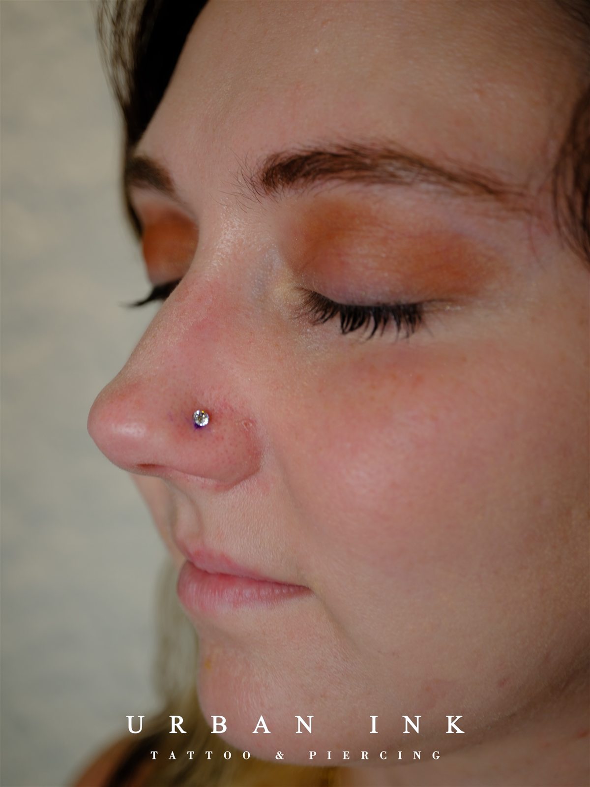 Minimal nostril solitaire piercing completed at Urban Ink