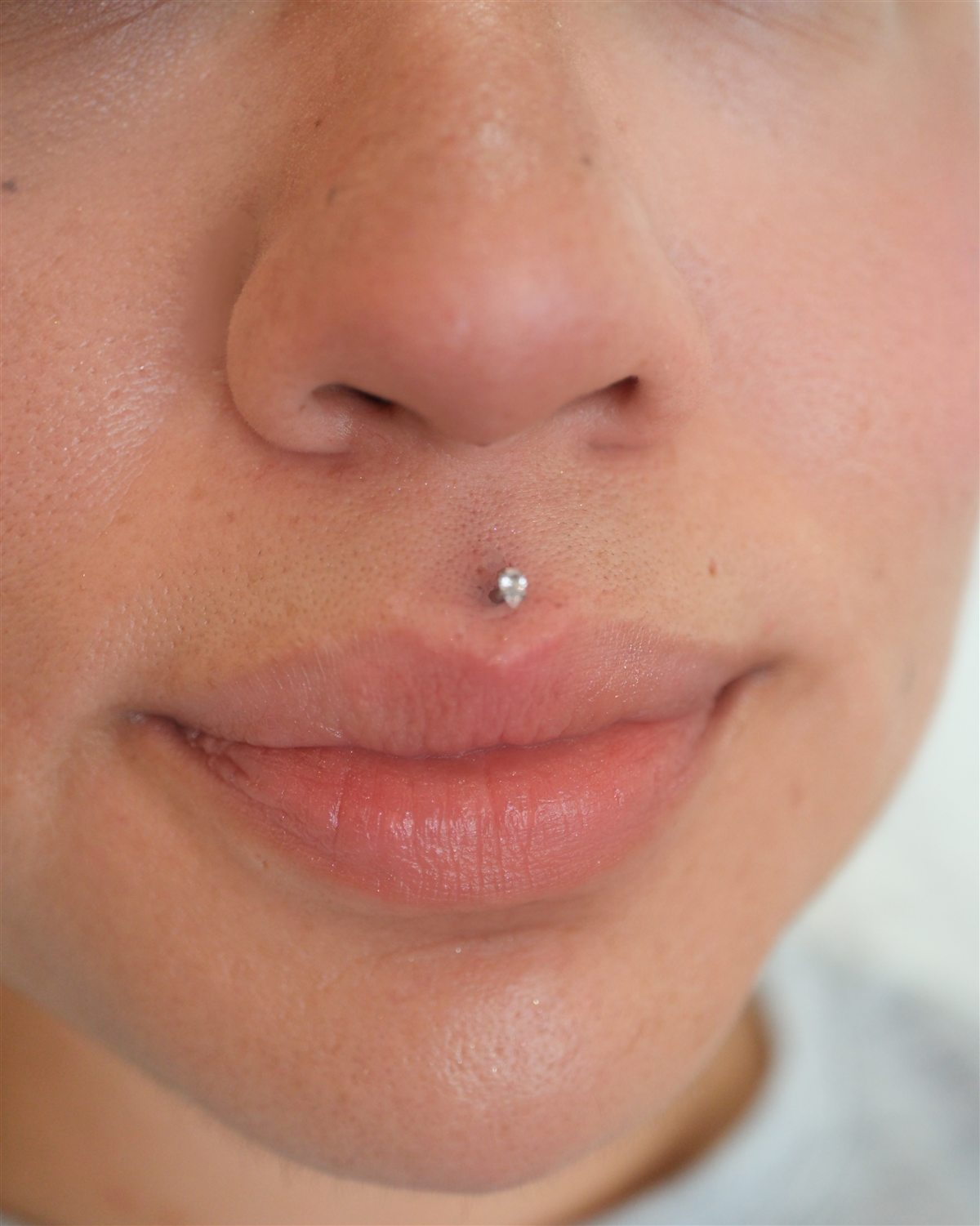 Upper-lip solitaire piercing completed at Urban Ink