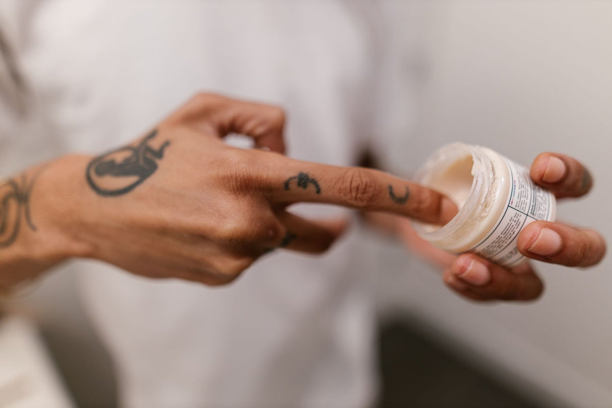 Close-up of tattoo aftercare cream application for a new tattoo healing guide