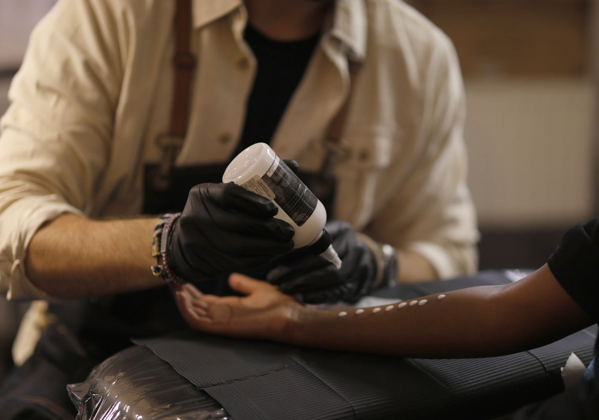 Tattoo artist preparing a client for a session while discussing tattoo payment planning