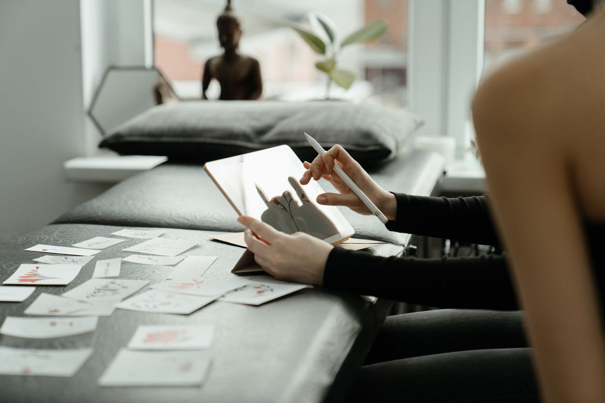 Tattoo consultation with a client reviewing custom design ideas on a tablet