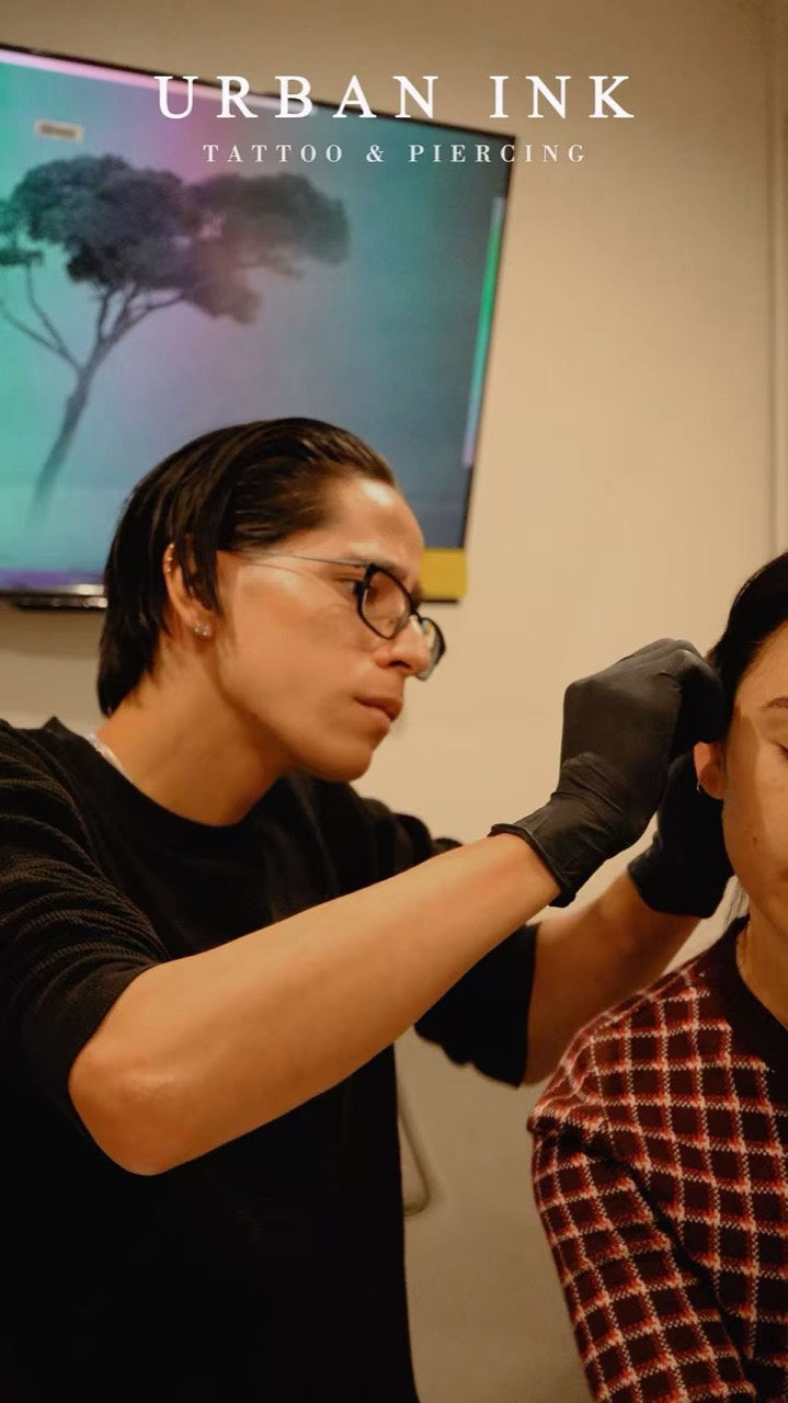 Michael, a piercing artist at Urban Ink, performing an ear piercing